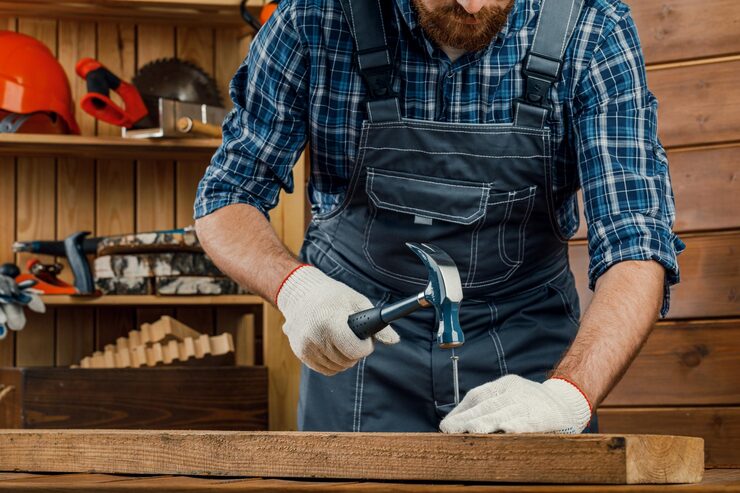 man-is-carpenter-hammering-nail-into-board-concept-renovation-construction_544249-7412